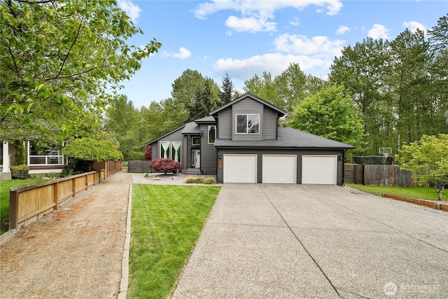 6411 86th Street Ct E, Puyallup, WA 98371 - view of front facade with fence, roof with shingles, an attached garage, a front yard, and concrete driveway