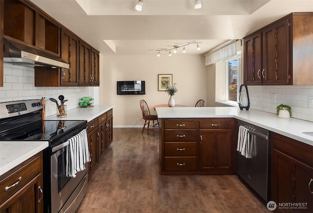 kitchen featuring dark wood-style flooring, a peninsula, light countertops, under cabinet range hood, and appliances with stainless steel finishes