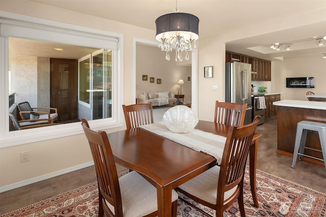 dining room with baseboards and a notable chandelier