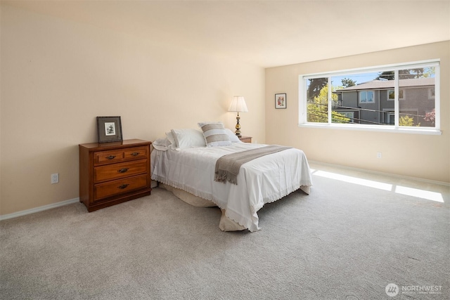 bedroom with baseboards and light carpet