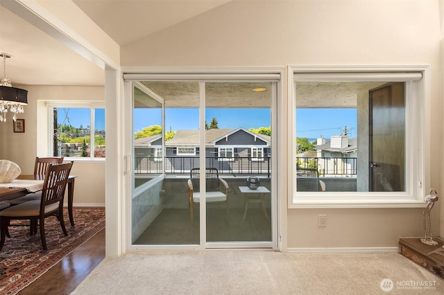 entryway featuring baseboards, a notable chandelier, and lofted ceiling