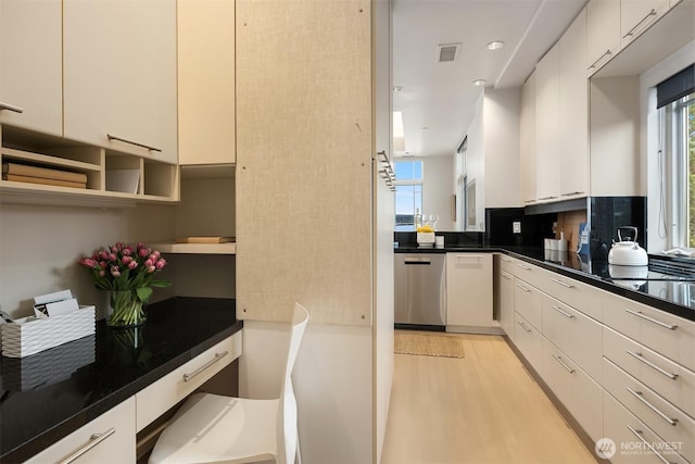 kitchen with visible vents, dark countertops, dishwasher, light wood finished floors, and white cabinetry