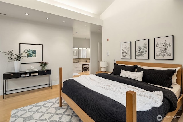 bedroom featuring recessed lighting, ensuite bath, and wood finished floors