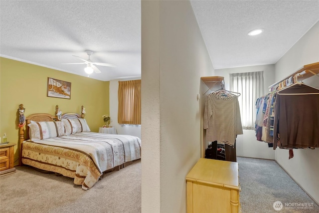 bedroom featuring ceiling fan, carpet flooring, and a textured ceiling