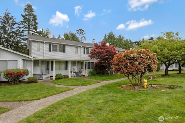 view of front of home featuring a porch, a front lawn, and a chimney