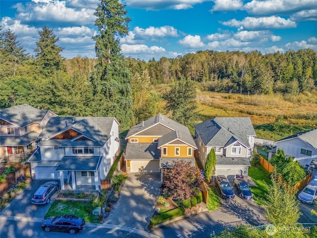 bird's eye view featuring a residential view and a wooded view