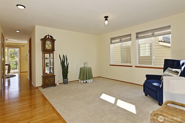 sitting room with baseboards and light wood-style floors