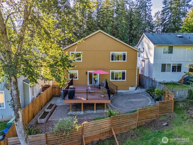rear view of house featuring a fenced backyard and a wooden deck