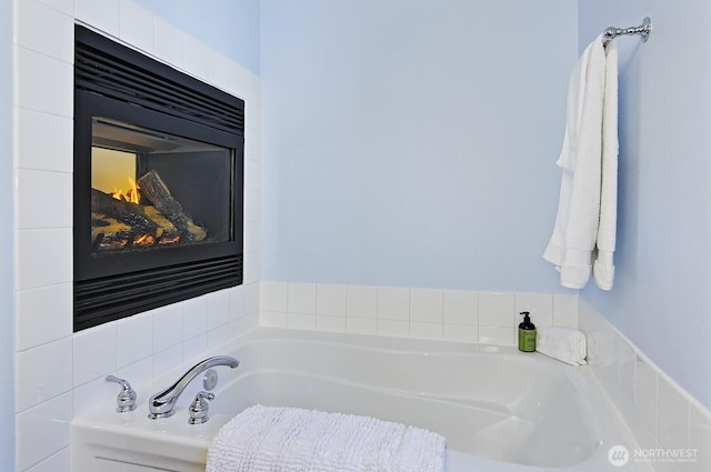 full bath featuring a glass covered fireplace and a bath