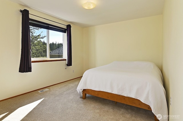 carpeted bedroom featuring baseboards and visible vents