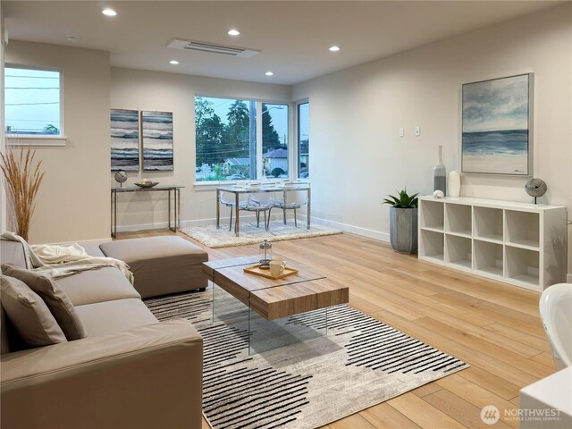 living room featuring recessed lighting, visible vents, plenty of natural light, and wood finished floors