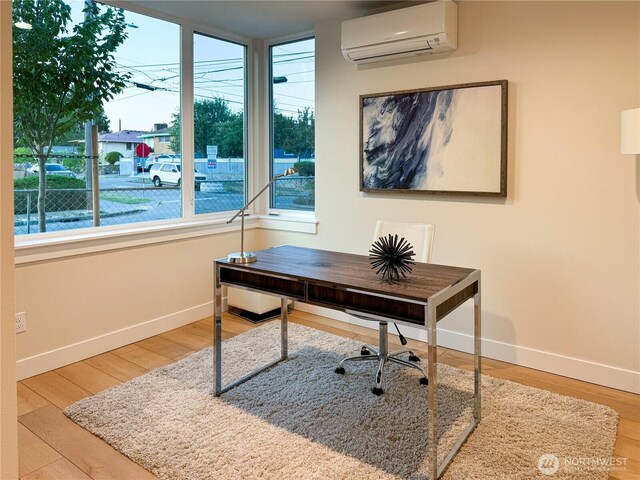 home office featuring baseboards, plenty of natural light, and a wall mounted air conditioner