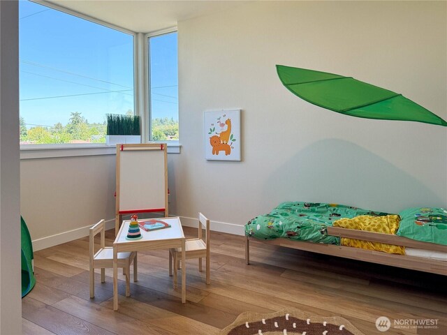 playroom featuring baseboards and wood finished floors