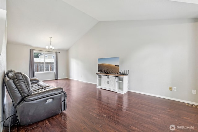 living area featuring visible vents, wood finished floors, baseboards, lofted ceiling, and an inviting chandelier