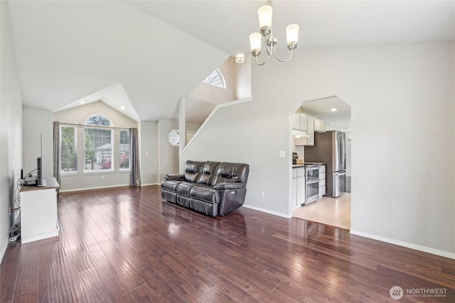 living room with wood finished floors, lofted ceiling, recessed lighting, a chandelier, and arched walkways