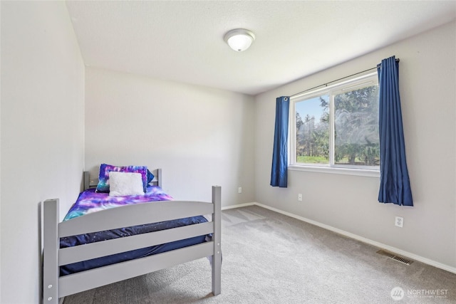 carpeted bedroom with baseboards and visible vents