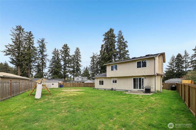 back of property with a lawn and a fenced backyard