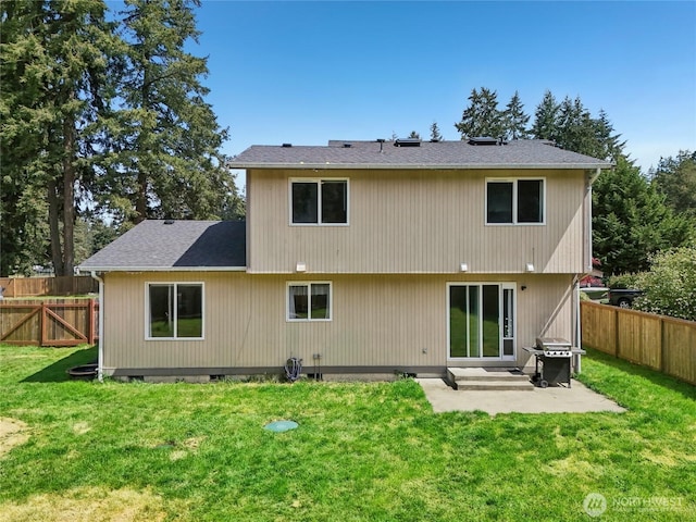 back of house featuring a yard, a shingled roof, a fenced backyard, and a patio area