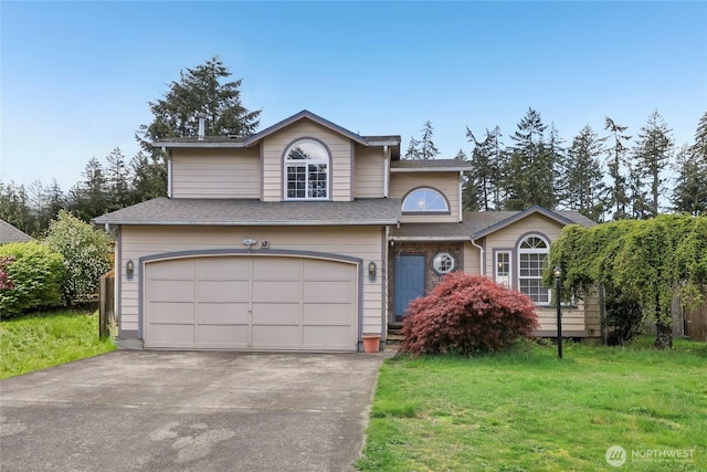 view of front of house with an attached garage, a shingled roof, a front lawn, and aphalt driveway