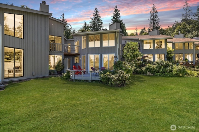 2877N Nugent Rd Unit M4, Lummi Island, WA 98262 - back of property at dusk with a chimney, a lawn, a balcony, and a patio area