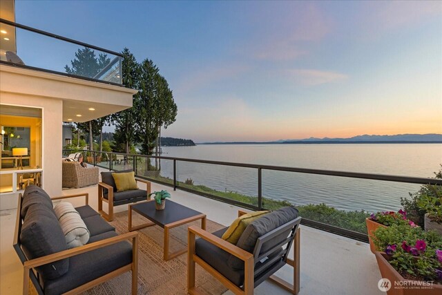 balcony featuring a water view and outdoor lounge area