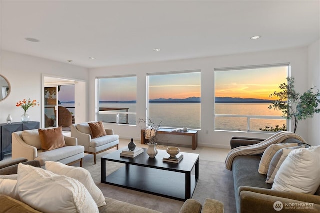 carpeted living area featuring recessed lighting and a water view