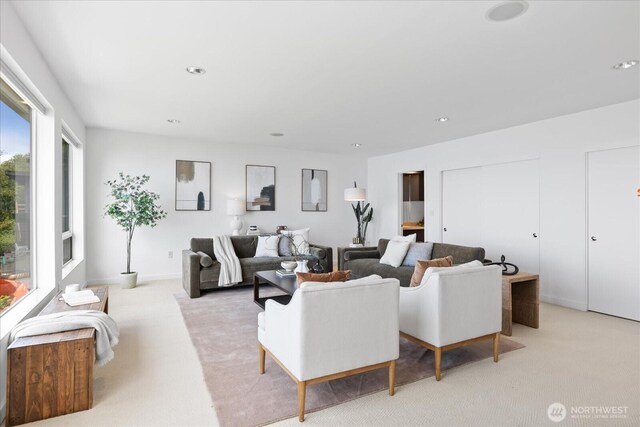 living area with light carpet and recessed lighting