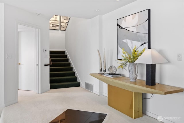 stairway featuring visible vents and carpet floors