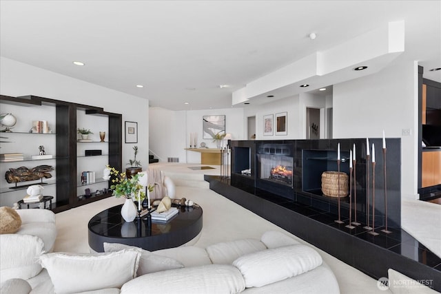 living room featuring recessed lighting and a multi sided fireplace