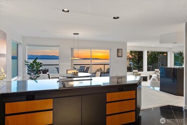kitchen with dark countertops, black electric cooktop, dark tile patterned flooring, open floor plan, and recessed lighting