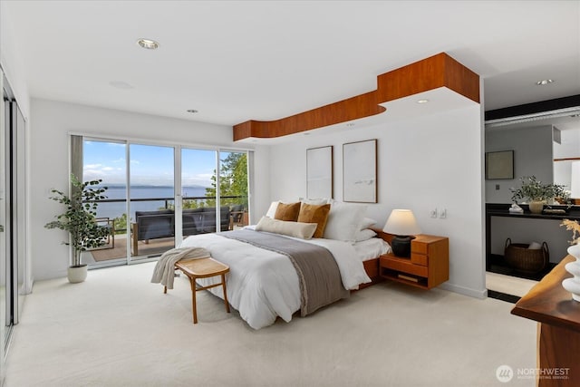 bedroom featuring a water view, access to outside, recessed lighting, and light colored carpet