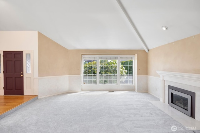 23812 21st Dr SE, Bothell, WA 98021 - unfurnished living room with a tiled fireplace, a wainscoted wall, vaulted ceiling with beams, and carpet floors