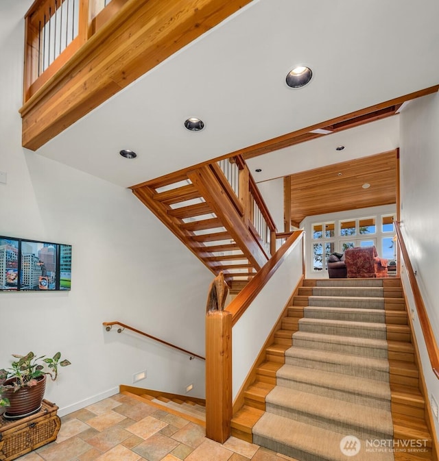 staircase with recessed lighting, baseboards, and stone finish floor