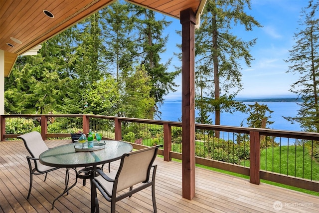 wooden terrace with a water view and outdoor dining space