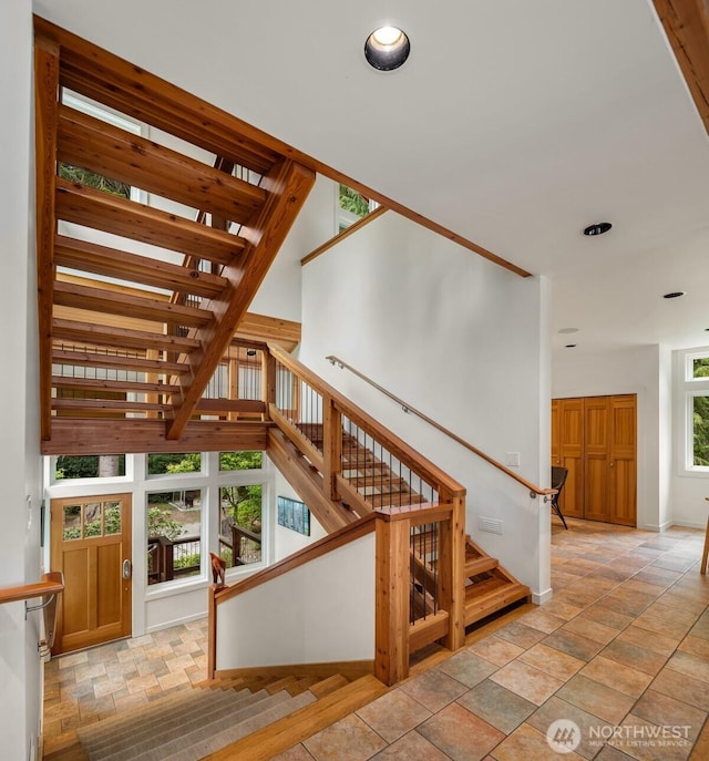 stairs featuring stone tile floors, recessed lighting, and baseboards