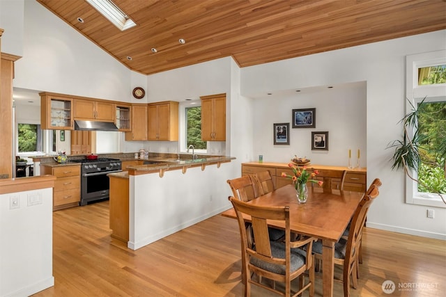 kitchen featuring a peninsula, glass insert cabinets, gas range, wood ceiling, and brown cabinets
