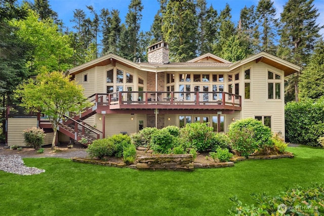 rear view of property with a lawn, a wooden deck, stairs, and a chimney