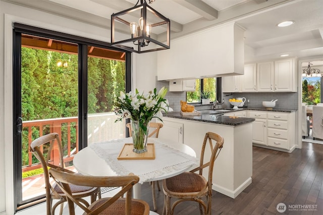 dining area with recessed lighting, beam ceiling, a notable chandelier, and dark wood finished floors
