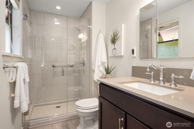 full bathroom featuring vanity, recessed lighting, a stall shower, and toilet