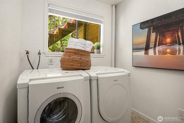 washroom featuring laundry area, baseboards, and washing machine and dryer