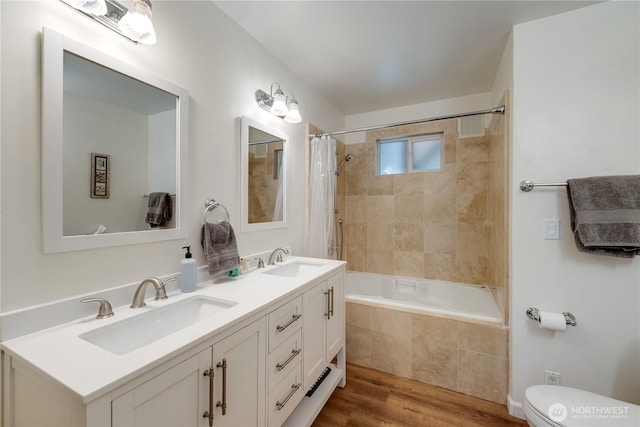 6160 NE 185th St, Kenmore, WA 98028 - bathroom with double vanity, tiled shower / bath, wood finished floors, and toilet
