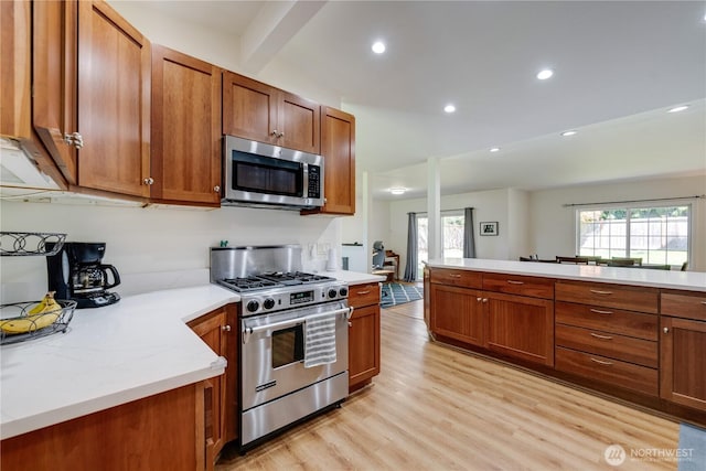 6160 NE 185th St, Kenmore, WA 98028 - kitchen with appliances with stainless steel finishes, brown cabinetry, light wood finished floors, recessed lighting, and beamed ceiling