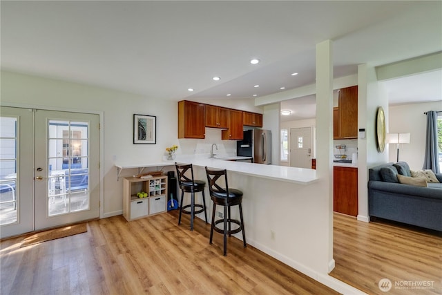 6160 NE 185th St, Kenmore, WA 98028 - kitchen featuring freestanding refrigerator, light wood-style flooring, a peninsula, brown cabinets, and recessed lighting