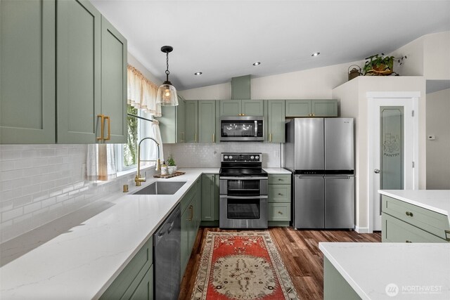 kitchen featuring appliances with stainless steel finishes, a sink, and green cabinets