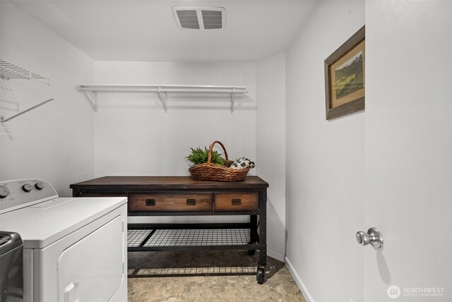 washroom with baseboards, laundry area, visible vents, and washer and clothes dryer