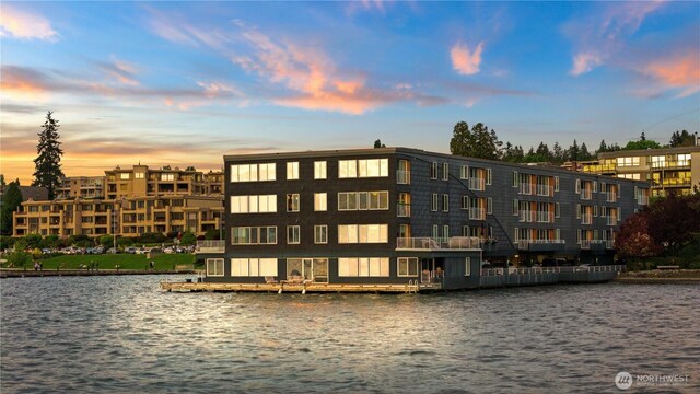 property at dusk featuring a water view