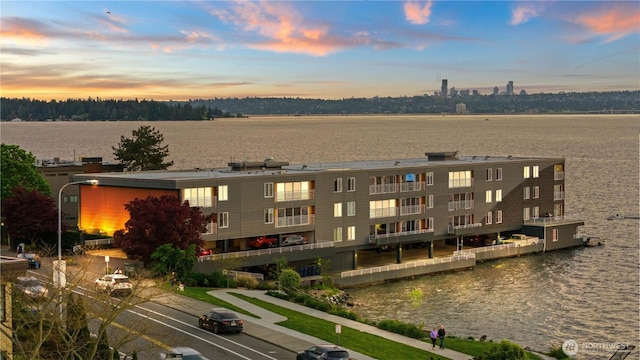 property at dusk featuring a water view
