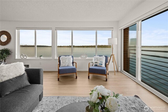sunroom / solarium featuring a water view