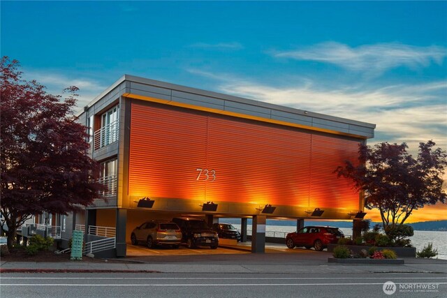 view of building exterior featuring covered and uncovered parking