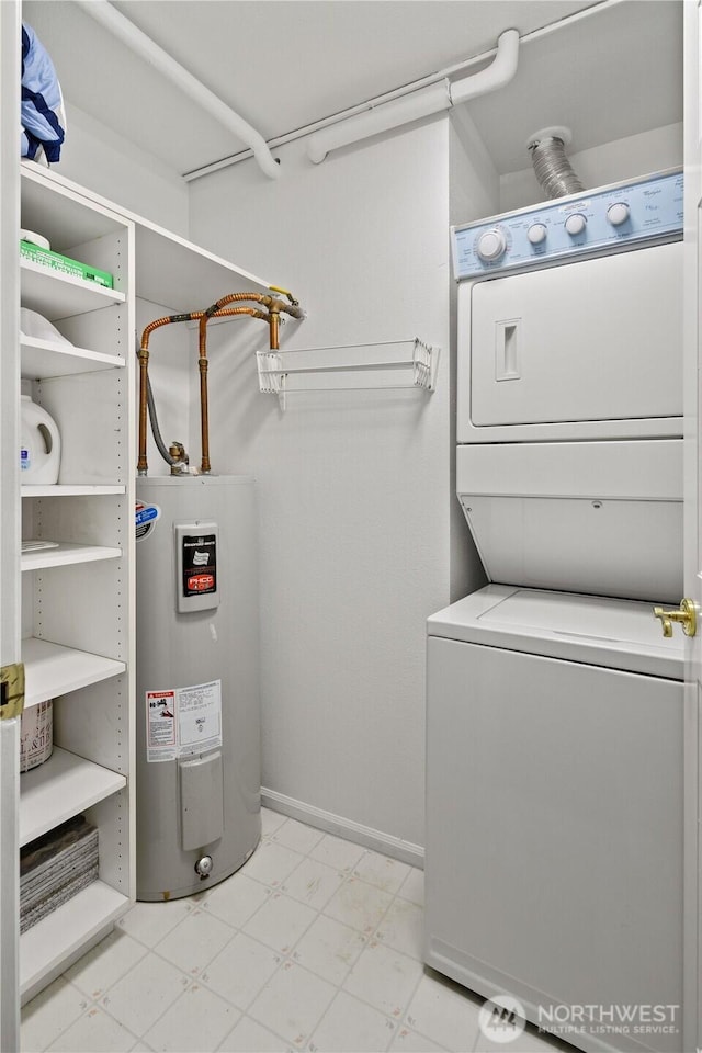 laundry room featuring stacked washer / dryer, water heater, light flooring, and baseboards